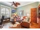 Inviting living room featuring hardwood floors, a ceiling fan, and a leather sofa at 2512 Baywater Rd, Tavares, FL 32778
