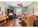 Comfortable living room featuring hardwood floors, a ceiling fan, and a cozy seating area at 2512 Baywater Rd, Tavares, FL 32778