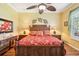 Comfortable bedroom with a ceiling fan, hardwood floors, and a large carved wooden bed at 2512 Baywater Rd, Tavares, FL 32778