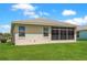 Lush backyard with a well-maintained lawn and view of the home's sunroom at 27328 Pine Straw Rd, Leesburg, FL 34748