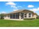 Backyard of the house with a well-maintained lawn and a sunroom at 27328 Pine Straw Rd, Leesburg, FL 34748