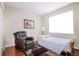 Cozy bedroom with a bed, leather chair and bright window at 27328 Pine Straw Rd, Leesburg, FL 34748