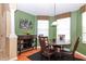 Dining area with green walls, wood table, and natural light from bay windows at 27328 Pine Straw Rd, Leesburg, FL 34748