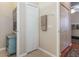 Hallway with white doors, towel rack, and view into another room at 27328 Pine Straw Rd, Leesburg, FL 34748