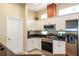 Well-lit kitchen with stainless steel appliances, white cabinets, and a tiled floor at 27328 Pine Straw Rd, Leesburg, FL 34748