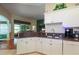 Kitchen with stainless steel sink, white cabinetry, and granite counters overlooks dining area at 27328 Pine Straw Rd, Leesburg, FL 34748