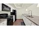 Modern kitchen with granite countertops, stainless steel sink, and black appliances at 2815 Spyglass Cv, Longwood, FL 32779