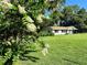 Charming single-story home with a large yard, inviting front porch, and mature trees providing ample shade at 32511 Purdum Ave, Leesburg, FL 34788