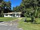 Attractive single-story home with a well-maintained yard, inviting front porch, and a functional carport at 32511 Purdum Ave, Leesburg, FL 34788