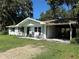 Charming home with rocking chairs on the front porch and attached carport at 32511 Purdum Ave, Leesburg, FL 34788
