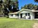 Inviting single-story home with a well-kept lawn, a charming front porch with seating, and a cozy exterior at 32511 Purdum Ave, Leesburg, FL 34788