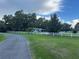Home featuring a white fence and beautiful trees in a serene outdoor setting at 32511 Purdum Ave, Leesburg, FL 34788