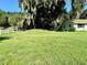 Expansive front yard with lush lawn and mature trees, offering a serene and inviting curb appeal at 32511 Purdum Ave, Leesburg, FL 34788