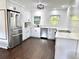 Modern kitchen with stainless steel appliances, white cabinetry, and beautiful backsplash with natural lighting at 32511 Purdum Ave, Leesburg, FL 34788