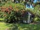 Garden shed surrounded by lush greenery and bougainvillea at 32511 Purdum Ave, Leesburg, FL 34788