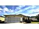 Inviting home featuring a well-maintained lawn, mature landscaping, and attached two car garage at 327 Bentwood Dr, Leesburg, FL 34748