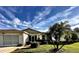 Charming home with manicured lawn, vibrant landscaping, and inviting front entrance at 327 Bentwood Dr, Leesburg, FL 34748