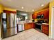 Well-equipped kitchen with stainless steel appliances, tile flooring, and warm-toned cabinetry at 327 Bentwood Dr, Leesburg, FL 34748