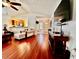 Cozy living room showcasing hardwood floors, comfortable armchair, and a view of the kitchen at 327 Bentwood Dr, Leesburg, FL 34748
