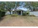 Spacious backyard with green grass, mature trees and a covered patio area at 33441 Irongate Dr, Leesburg, FL 34788