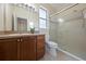 Bathroom featuring a single sink vanity with wooden cabinets and a walk-in shower with glass doors at 33441 Irongate Dr, Leesburg, FL 34788