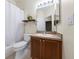 Bathroom featuring a shower-tub combo, single sink vanity, and a decorative plant on a floating shelf at 33441 Irongate Dr, Leesburg, FL 34788