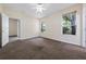 Bedroom with neutral carpet, bright windows, and a ceiling fan for added comfort and energy efficiency at 33441 Irongate Dr, Leesburg, FL 34788