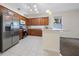 Open kitchen featuring tile floors, stainless steel appliances, and wood cabinets at 33441 Irongate Dr, Leesburg, FL 34788