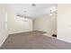Spacious living room featuring neutral carpet, modern lighting fixtures, and large windows for natural light at 33441 Irongate Dr, Leesburg, FL 34788
