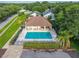 Community pool featuring a large swimming area, seating under a roof, and palm trees at 33441 Irongate Dr, Leesburg, FL 34788