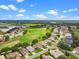 A view of a neighborhood with a golf course and a lake in the background on a bright sunny day at 4909 Kelso St, Leesburg, FL 34748