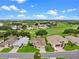 Aerial view of a single Gathering home with manicured lawn in a lovely neighborhood next to a golf course and a lake at 4909 Kelso St, Leesburg, FL 34748