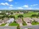 Aerial view of a single Gathering home with manicured lawn in a lovely neighborhood next to a golf course and a lake at 4909 Kelso St, Leesburg, FL 34748