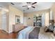 Bedroom with a ceiling fan, wood floors, and sliding glass doors to outdoor living space at 4909 Kelso St, Leesburg, FL 34748
