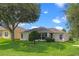 Exterior view of the home with a well-manicured lawn and mature trees at 4909 Kelso St, Leesburg, FL 34748