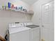 Laundry room with a full-size washer and dryer and wire shelving at 4909 Kelso St, Leesburg, FL 34748