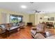 Bright living room featuring hardwood floors, ceiling fan, and sliding door access to the outdoors at 4909 Kelso St, Leesburg, FL 34748