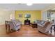 Bright living room with beautiful wood floors, electric fireplace, and access to the outdoors at 4909 Kelso St, Leesburg, FL 34748