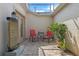 Private courtyard patio with a water feature, red chairs, and lush plants at 4909 Kelso St, Leesburg, FL 34748