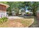 Wide shot of backyard showing mature trees, patio, and detached shed or garage at 501 Washington Ave, Eustis, FL 32726
