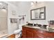 Modern bathroom with wood vanity, granite countertop, large mirror, and walk-in shower with glass doors at 501 Washington Ave, Eustis, FL 32726