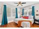 Cozy bedroom with bright teal curtains, plush pillows, and a white bedspread with a throw blanket at 501 Washington Ave, Eustis, FL 32726