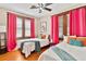 Bedroom with two beds and bright pink curtains offers a comfy and inviting space to unwind and rest at 501 Washington Ave, Eustis, FL 32726