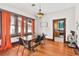 The dining room features hardwood floors, a modern chandelier, and large windows with orange curtains at 501 Washington Ave, Eustis, FL 32726