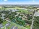 Aerial view of a property within a green landscape, featuring nearby school and residential areas at 504 Gilliam St, Wildwood, FL 34785
