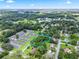 Aerial shot showing property line amidst lush surroundings, with nearby buildings and clear skies at 504 Gilliam St, Wildwood, FL 34785