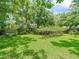 Expansive backyard featuring mature trees, pergola, and manicured lawn at 504 Gilliam St, Wildwood, FL 34785
