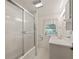 Bright, clean bathroom with a sliding glass door shower, white vanity, and window for natural light at 504 Gilliam St, Wildwood, FL 34785