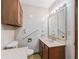 Bathroom featuring a vanity, toilet with grab bar, medicine cabinet, and vintage wallpaper at 504 Gilliam St, Wildwood, FL 34785