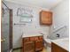 Bathroom featuring a vanity, toilet with grab bar, walk-in shower, and vintage wallpaper, offering accessibility features at 504 Gilliam St, Wildwood, FL 34785